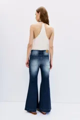 Pantalón de jean de tiro medio y calce ajustado desde la cintura hasta la rodilla, con pierna acampanada. Confeccionado en tejido confort con elastano, color azul con lavado localizado y bigotes. Cierre y botón. Forrería estampada con logo de la marca.