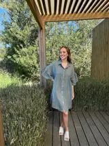 Vestido camisero azul de lino italiano, con cuello camisero, botones frontales, mangas 3/4 con doble volado y bolsillos laterales.