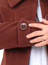 Abrigo de lana color beige, con corte clásico, botones distintivos y bolsillos prácticos.