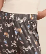 Pijama largo de poliéster y elastano, compuesto por una remera acanalada de manga corta y cuello redondo, y un pantalón largo con cintura elástica y estampado de perros deportistas.