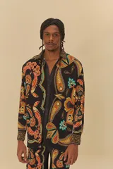 Camisa de poliéster negra con estampado de cachemir en tonos naranja, marrón, celeste y amarillo. Tiene cuello clásico, mangas largas y cierre frontal con botones.
