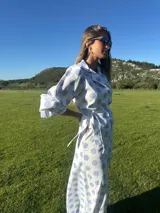 Camisa marrón con lunares blancos, corte clásico, cuello camisero, mangas 3/4 abullonadas y lazo ajustable en la cintura.