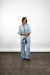 Blazer celeste de lino, con solapas de muesca, cierre frontal con dos botones, mangas largas con puños abotonados y bolsillos delanteros con solapa.