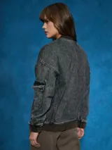 Campera de jean celeste con corte bomber, cierre frontal con botones metálicos, cuello redondo y puños y cintura acanalados.