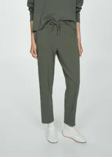 Pantalón verde militar de piqué con cintura elástica con cordón ajustable, corte recto, tiro alto, bolsillos laterales y costuras decorativas.