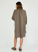 Vestido corto color ocre, con cuello mao, mangas largas abullonadas con detalle de encaje y corte evasé.