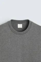 Camiseta verde militar de corte recto, cuello redondo y manga corta.