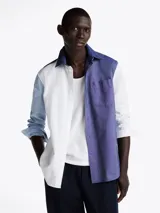 Camisa de manga larga con diseño color block en azul y blanco, confeccionada en algodón Oxford, con cuello abotonado, bolsillo de parche en el pecho, puños redondeados con botón y logo bordado en el bolsillo.