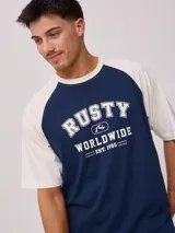 Remera azul marino con mangas raglán color crema y estampado frontal con el logo de Rusty en blanco.