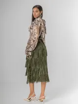 Maxi falda con múltiples capas de flecos, confeccionada en tela elastizada. Disponible en negro, beige y verde militar.