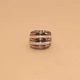 Anillo ancho de plata con detalles en oro y circonias. Diseño con bandas horizontales alternadas en plata lisa, oro con circonias y plata labrada.