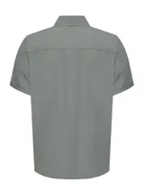 Camisa de manga corta color beige, con cuello clásico, cierre frontal con botones y bolsillo en el pecho izquierdo.