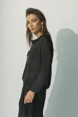 Blusa marrón con textura rayada, de mangas largas y escote en V con lazo ajustable.