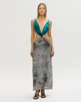 Vestido largo de corte irregular, con escote halter y espalda descubierta. La parte superior es de color turquesa y la falda es de color gris con estampado abstracto.