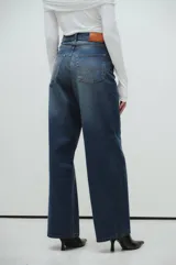 Pantalón de jeans azul oscuro, corte wide leg, tiro medio, calce extra relaxed y pierna ancha.
