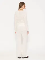 Pantalón de tejido calado color crudo con lentejuelas, de corte recto y silueta fluida.