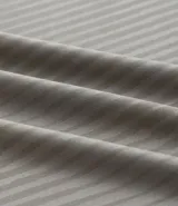 Remera deportiva de manga corta y cuello redondo, color beige claro, con textura acanalada vertical. Presenta detalles reflectantes en los hombros.