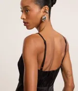 Vestido midi de satén negro con textura jacquard, escote en V, tirantes finos regulables y godets en el ruedo.