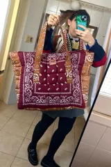 Bolso tipo tote de tela capitoneada con estampado de bandanas en tonos borgoña y marrón. Tiene cierre, interior con 5 bolsillos y exterior con 3 bolsillos.