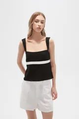 Top negro de viscosa con breteles anchos, escote cuadrado y corte ajustado. Presenta una franja horizontal blanca a la altura del busto.