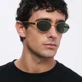 Lentes de sol ovalados con montura delgada dorada y patillas gruesas con estampado carey. Lentes polarizadas verdes con protección UV400.