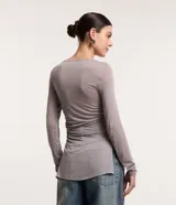Blusa de viscosa color gris con efecto gastado, cuello redondo, mangas largas, fruncido lateral y abertura.