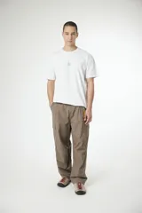 Remera blanca de manga corta con cuello redondo y un pequeño logo bordado en el pecho.