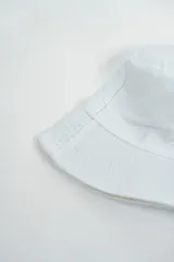 Gorro tipo bucket blanco con un bordado de una mariposa azul en el frente.