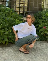 Remera blanca de algodón con corte oversize y estampado grande en la espalda de dos cerezas rojas unidas por el tallo, con el texto "Nude® Project" debajo.