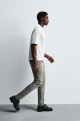 Pantalón de jean negro, corte slim fit, con tiro medio, cinco bolsillos, efecto lavado y cierre frontal con cremallera y botón.