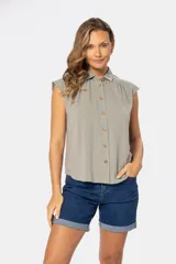 Camisa color beige de lino con botones de madera, cuello clásico y mangas cortas.