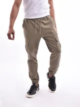 Pantalón jogger cargo color verde militar con cintura elástica ajustable con cordón, bolsillos laterales y bolsillos cargo con solapa en los muslos.
