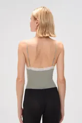 Body color verde oliva, de breteles finos y escote en V con terminación de encaje blanco.