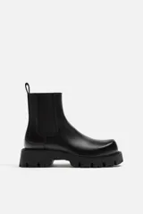 Bota Chelsea negra de cuero sintético, con elásticos laterales, tirador trasero y suela track.