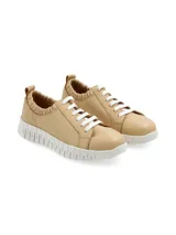 Sneaker color beige de cuero, con suela anatómica blanca y detalle de elástico en el tobillo. Diseñado en Uruguay y fabricado en colaboración con Relaxshoe.