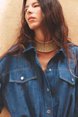 Cazadora de denim azul con mezcla de algodón y lino. Tiene cuello solapa, manga corta con vuelta y trabilla con botón, bolsillos de plastrón en el delantero, bajo elástico y cierre frontal con botones.