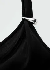 Vestido largo negro de punto fino con diseño asimétrico, un hombro descubierto, manga larga y detalle metálico en el hombro.