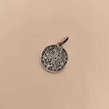 Medalla religiosa redonda de plata 925 con la imagen de San Benito de Nursia, con barba y hábito monacal, sosteniendo una cruz y un libro. Alrededor de la imagen se lee la inscripción "S. BENEDICTVS MONACHORVM PATRIARCHA PAX".