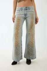 Pantalón de jean de corte wide leg con estampado de piel de serpiente en tonos marrones y celestes.