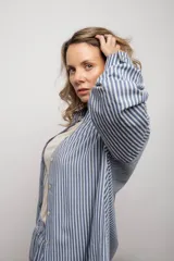 Camisa a rayas verticales azules y blancas, de manga larga con botones.