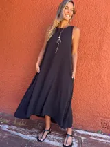 Vestido largo negro de seda opaca, con bolsillos laterales, corte en A y diseño con cortes laterales en la espalda.