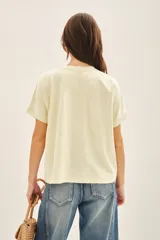 Buzo color crema de rústico de algodón, de calce holgado y manga corta. Posee un bordado central de inspiración botánica con lentejuelas.