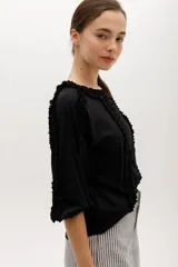 Blusa color beige de manga 3/4 confeccionada en algodón suave, con escote a la base y detalles de volados en 3D que recorren el frente, mangas y escote.