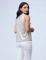 Blusa sin mangas de microtul bordado con lentejuelas color beige, con cuello alto y forro interno a tono.