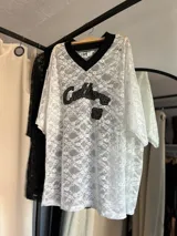 Remerón de encaje negro con mangas 3/4 y cuello camisero.