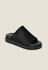 Sandalias bajas negras con capellada de cuero con terminación en pelo y logo bordado en el lateral.