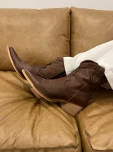 Botas texanas cortas de cuero color marrón chocolate, con punta fina, caña baja y taco de madera.