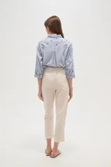 Pantalón de algodón color beige, de corte recto y largo a media pierna.