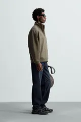 Sudadera negra de algodón con cuello alto y cierre de cremallera. Corte relaxed fit, manga larga y terminaciones en rib.