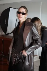 Trench de cuero ovino color chocolate con detalles en pasamanería de cueros en tonos tierra. Tiene lazos en mangas y espalda para entallar.